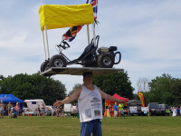 John Evans balances dirt go-kart on top of his head